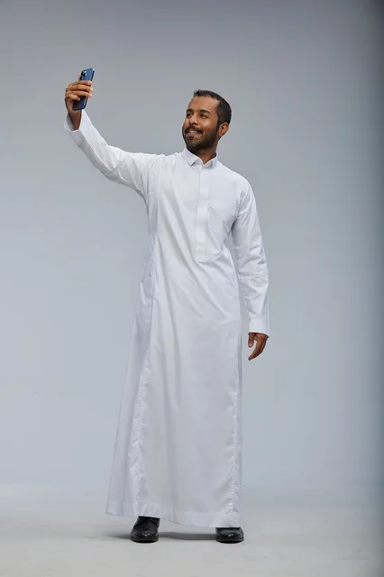 Saudi Man in White Thobe Taking Smartphone Selfie