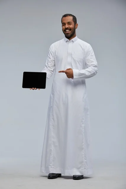 رجل سعودي بالثوب الأبيض يحمل جهاز لوحي ذكي استوديو