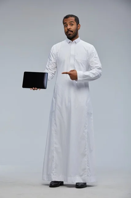 Saudi Man in White Thobe Holding Tablet Device