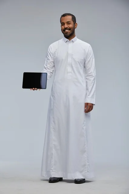 Saudi Man in White Thobe Holding Digital Tablet Device