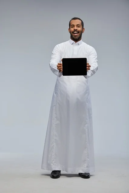 Saudi Man in White Thobe Holding Tablet Studio Shot