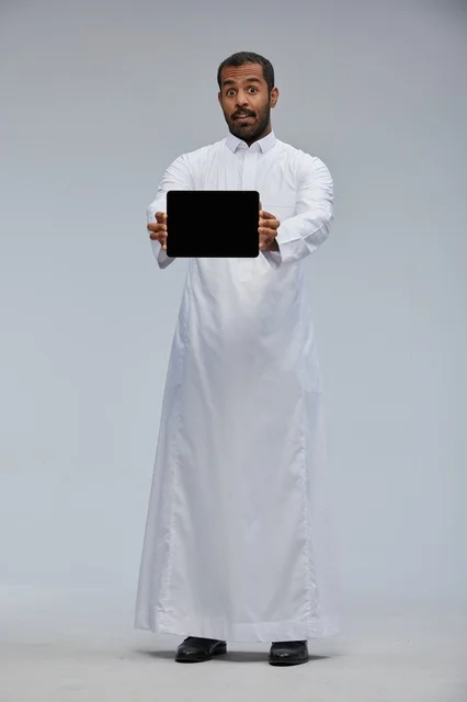 Saudi Man in Traditional Thobe Presenting Tablet Screen