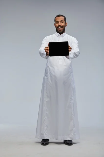 Saudi Man in White Thobe Holding Tablet Computer Saudi Man in White Thobe Holding Tablet Computer
