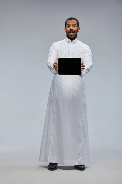 Saudi Man in White Thobe Holding Tablet Studio Portrait