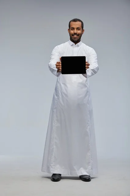 رجل سعودي بالثوب الأبيض يعرض جهاز لوحي