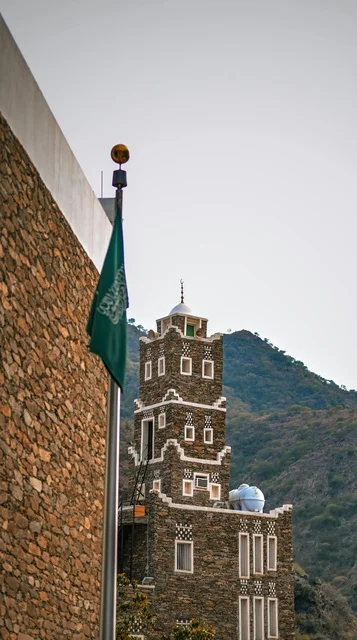 Saudi Flag and Traditional Stone Tower in Asir Mountains