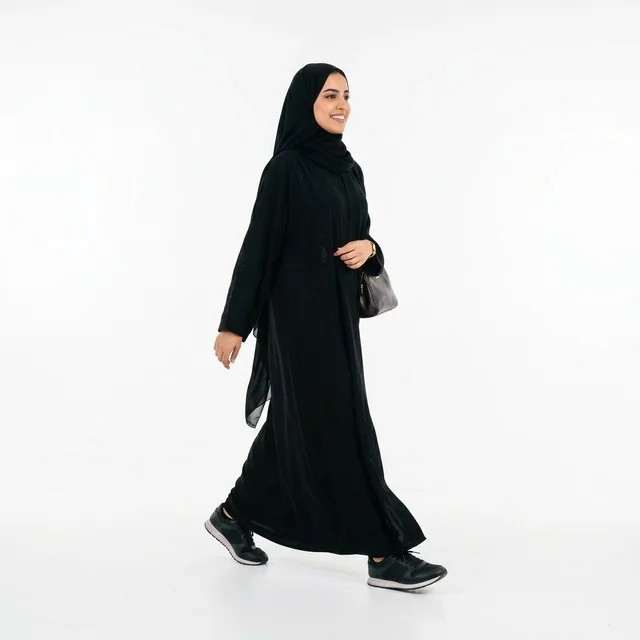 امرأة عربية تمشي بالعباءة السوداء على خلفية بيضاء امرأة عربية تمشي بالعباءة السوداء على خلفية بيضاء