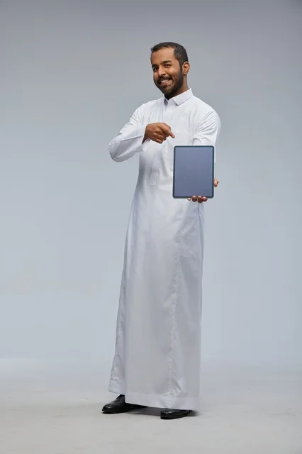 Saudi Man in White Thobe Presenting Digital Tablet