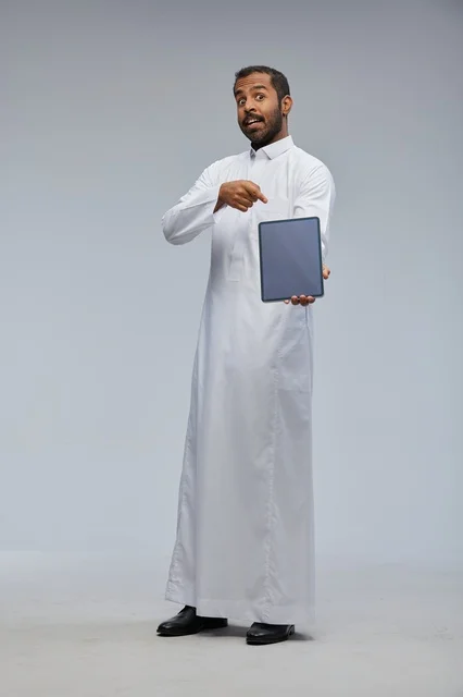 رجل سعودي بالثوب التقليدي يحمل جهاز لوحي