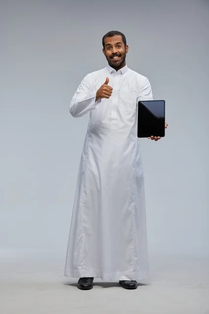 Saudi Man in White Thobe Holding Tablet and Thumbs Up
