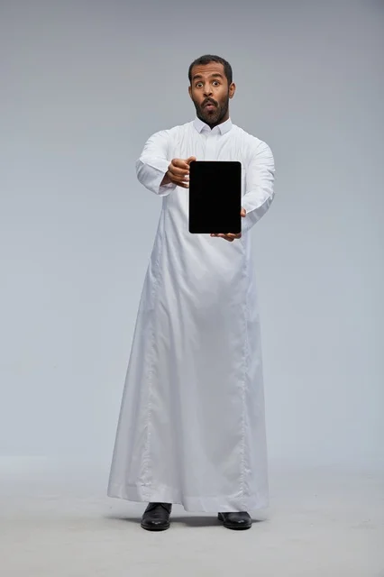 Saudi Man in Thobe Holding Tablet with Surprise