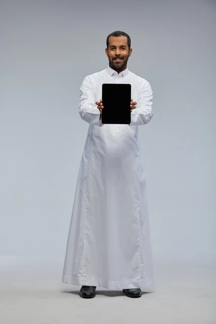 Saudi Man in White Thobe Holding Digital Tablet in Studio