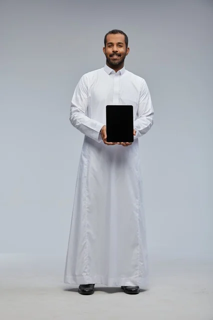Saudi Man in White Thobe Holding Digital Tablet in Studio
