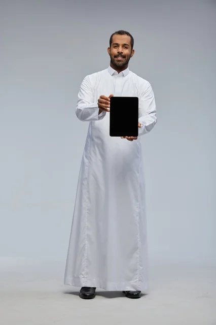 Saudi Man in White Thobe Holding Digital Tablet in Studio