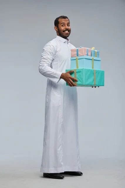Saudi Man in Thobe Holding Stack of Gift Boxes