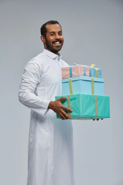 Saudi Man in Traditional Thobe Holding Gift Boxes