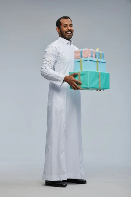 Saudi Man Holding Wrapped Gift Boxes on Gray Background