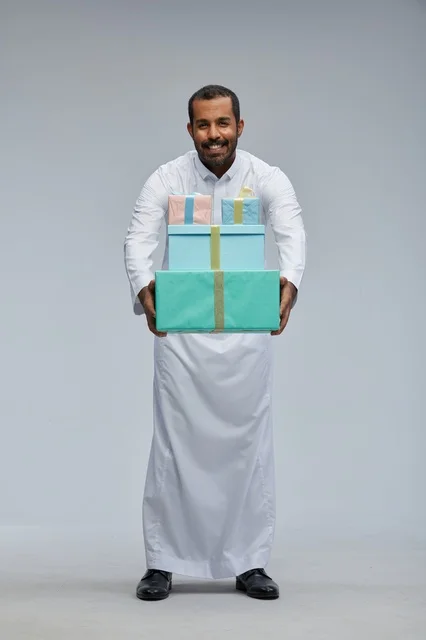 Saudi Man in Traditional Thobe Holding Gift Boxes