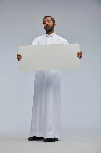 Saudi Man in Traditional Thobe Holding Blank Sign