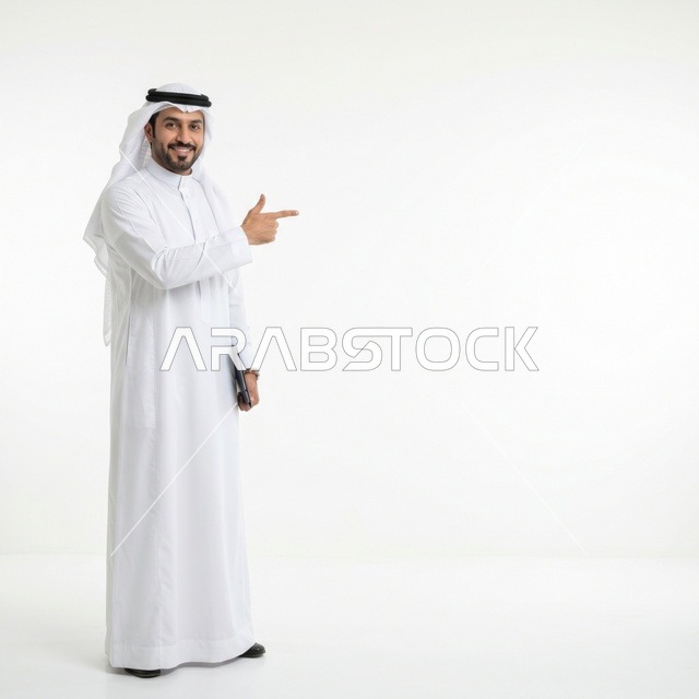 رجل أعمال سعودي يشير لمساحة فارغة خلفية بيضاء