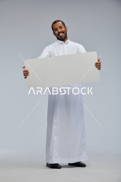 رجل سعودي بالثوب التقليدي يحمل لوحة بيضاء فارغة