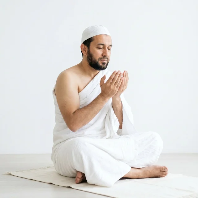 Muslim Man in Ihram Performing Dua on Prayer Mat