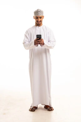 Omani Man in Traditional Dishdasha Using Smartphone