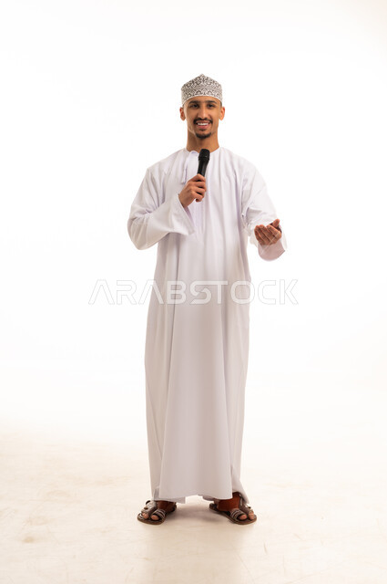 رجل عماني بالزي التقليدي يمسك بميكروفون