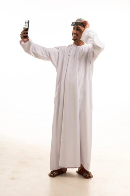 Omani Man in Traditional Dishdasha Taking a Selfie