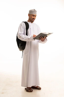 طالب عماني يقرأ كتاباً بخلفية بيضاء