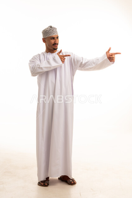 رجل عماني بالزي التقليدي يشير إلى الجانب