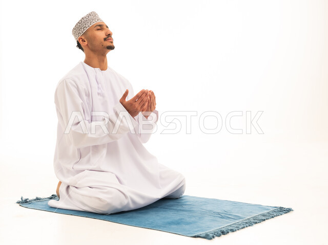 Omani Man in Traditional Dress Praying on White Background