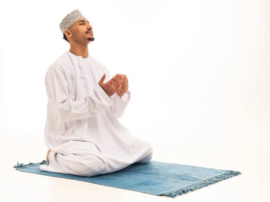 Omani Man in Traditional Dress Praying on White Background