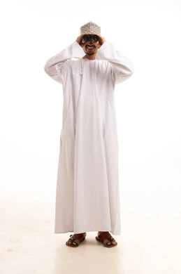 رجل عماني بالزي التقليدي يستخدم المنظار