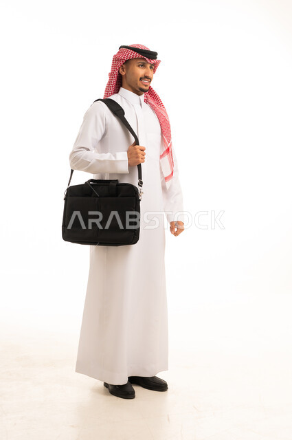 رجل سعودي بالزي التقليدي يحمل حقيبة حاسوب
