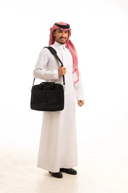 رجل سعودي يحمل حقيبة حاسوب محمول بالزي التقليدي