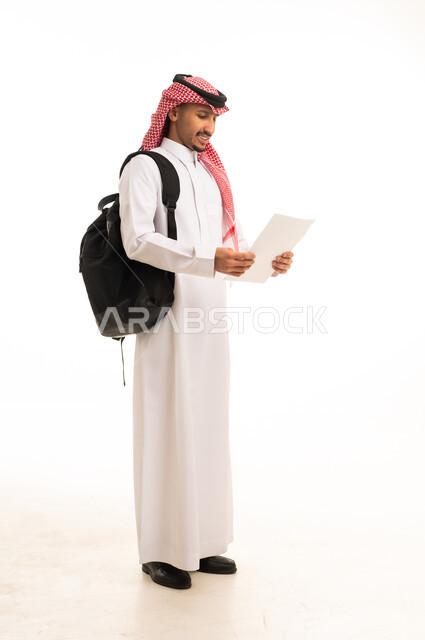 طالب سعودي يرتدي الثوب ويحمل حقيبة وورقة