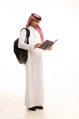 طالب سعودي بالزي التقليدي يقرأ كتاباً