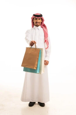 رجل سعودي يحمل حقائب تسوق بالزي التقليدي