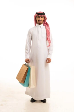 رجل سعودي بالزي التقليدي يحمل أكياس تسوق