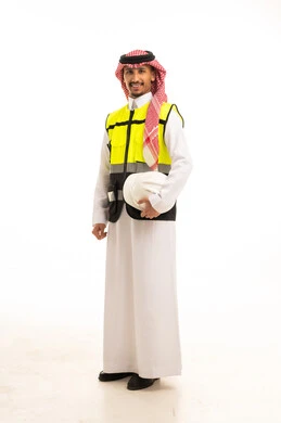 مهندس سعودي يرتدي سترة السلامة ويحمل خوذة العمل