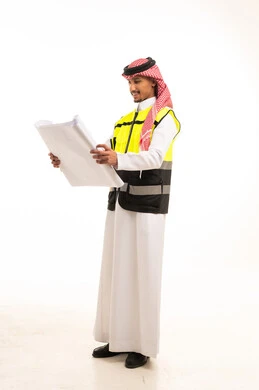 مهندس سعودي مع مخططات بناء على خلفية بيضاء