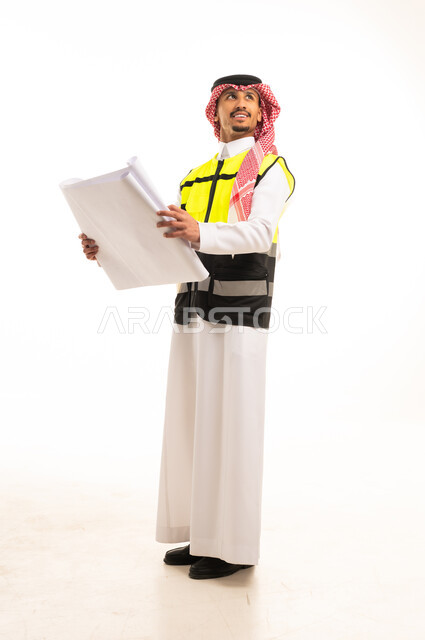 مهندس سعودي يمسك مخططات هندسية بخلفية بيضاء