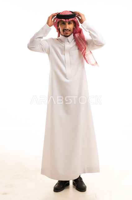 رجل سعودي بالثوب التقليدي يعدل العقال