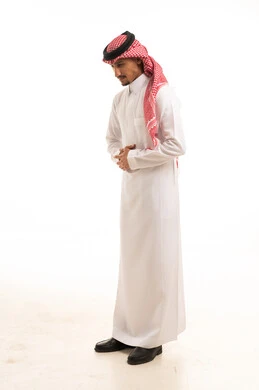 رجل سعودي بالثوب التقليدي والشماغ يقف في الاستوديو