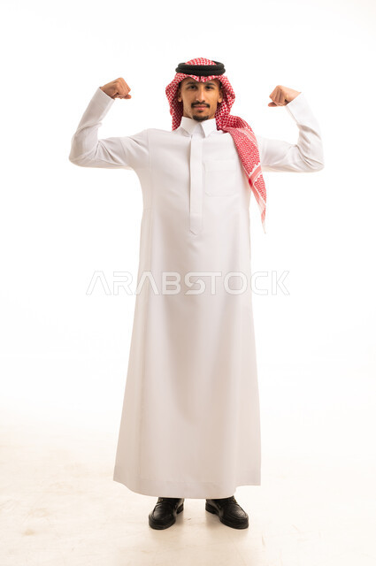 رجل سعودي بالزي التقليدي يستعرض عضلاته في الاستوديو