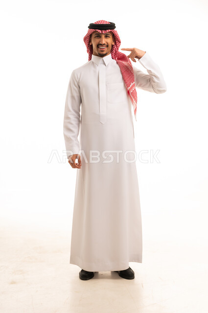 رجل سعودي بالثوب التقليدي يشير إلى رأسه