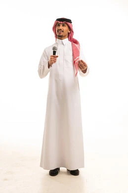 رجل سعودي يمسك ميكروفون بالثوب التقليدي