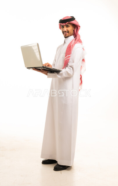 رجل سعودي يستخدم حاسوب محمول خلفية بيضاء