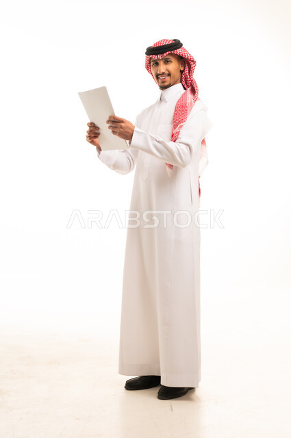 رجل أعمال سعودي بالثوب التقليدي يمسك ملف ورقي رسمي